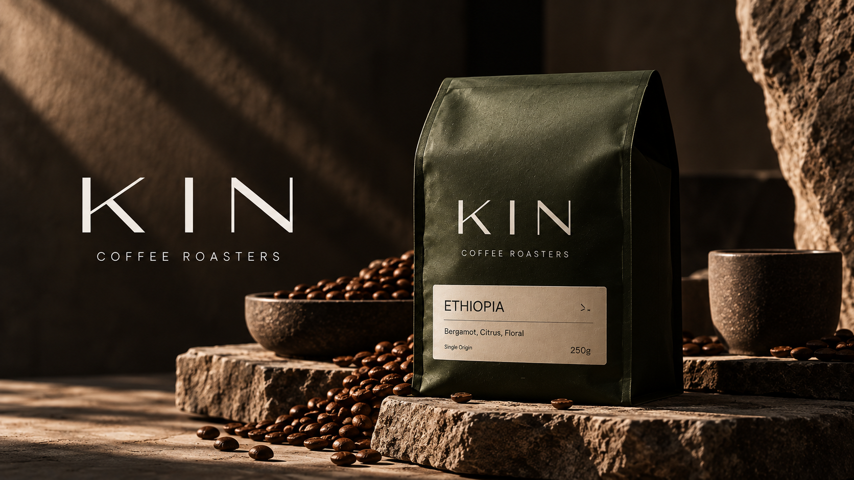 KIN coffee bag on stone beside a bowl of roasted beans